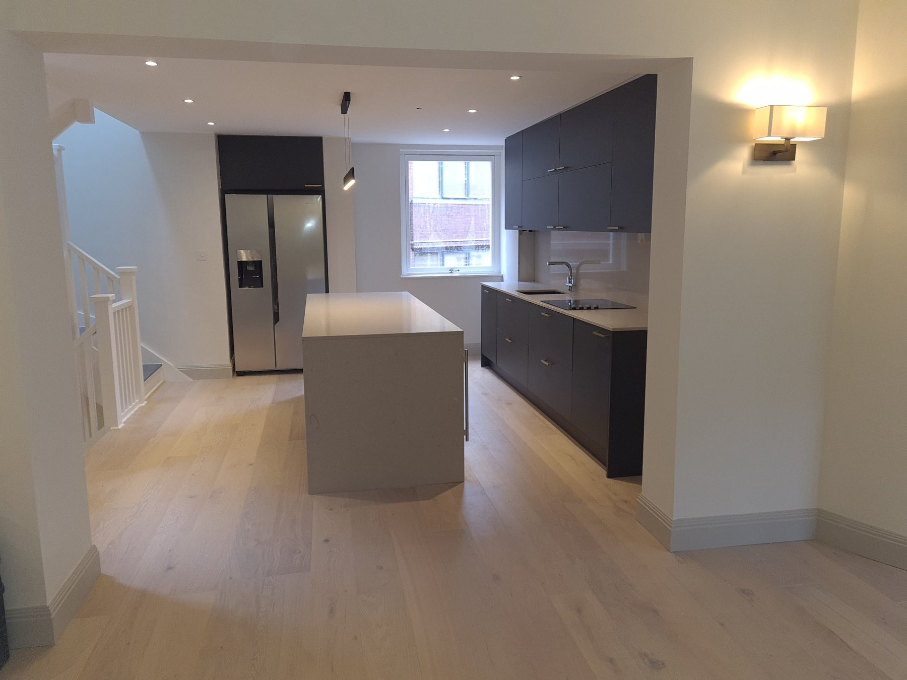 Completed open-plan kitchen with island and integrated lighting
