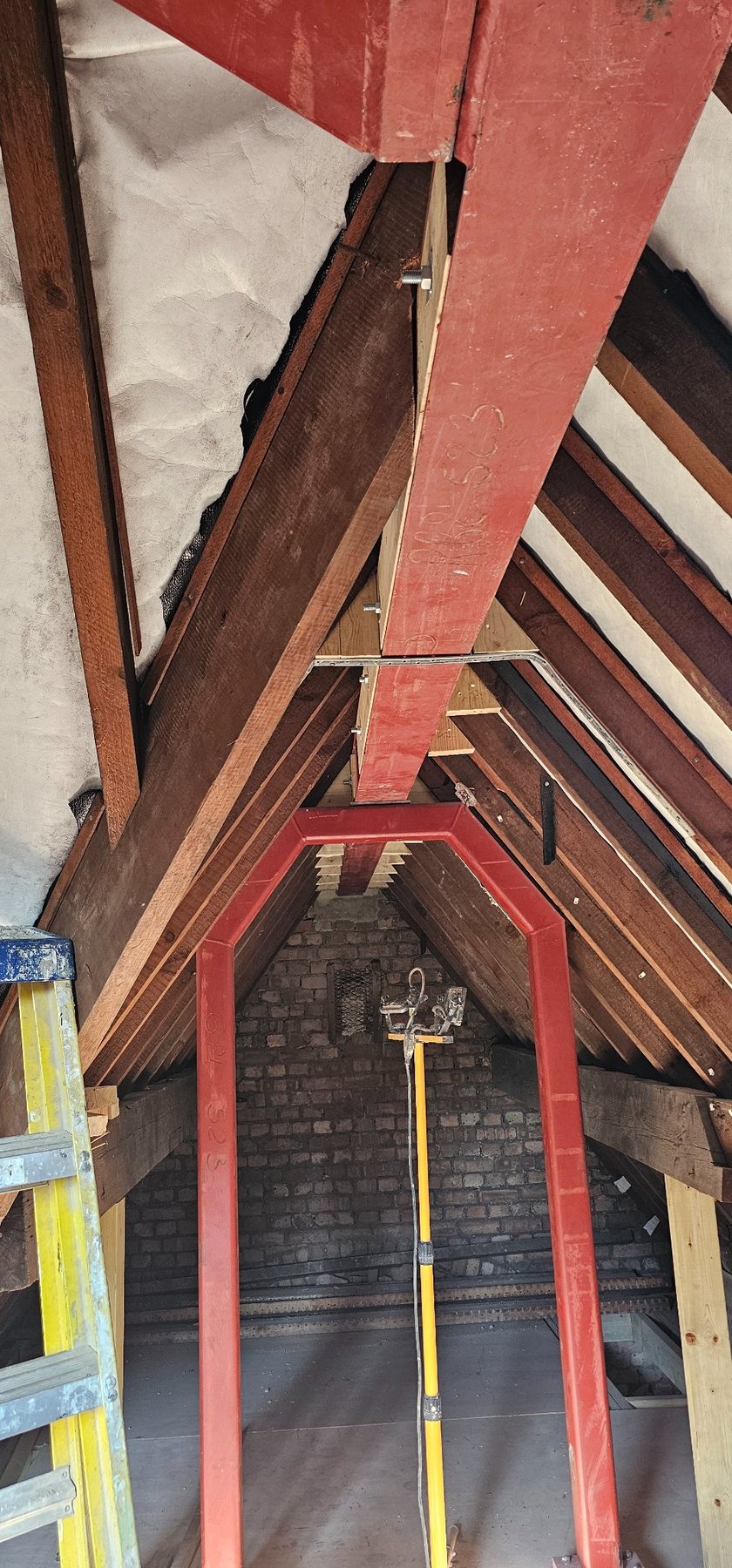 Steel ridge beam and goalpost frame installed within an existing roof